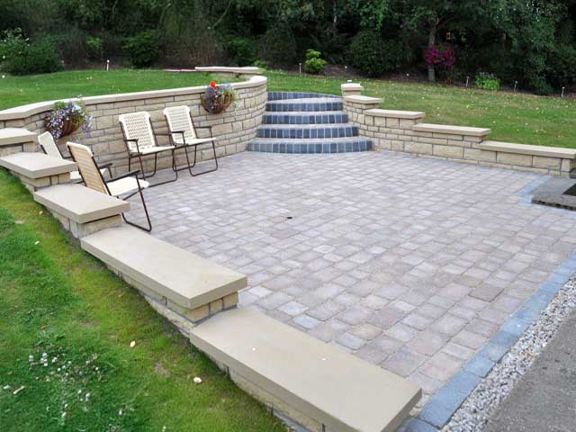 Master-level paver and flagstone patio installation featuring retaining walls and steps in Syracuse NY