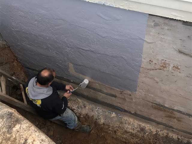 Professional application of a sub-grade foundation waterproofing membrane by A-Z Construction to prevent basement leaks and structural water damage in Syracuse, NY.