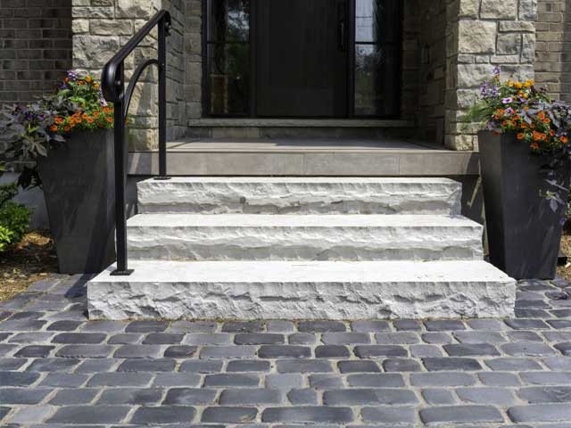 Hand-cut natural stone steps and a matching flagstone walkway designed to improve residential curb appeal and drainage in Fayetteville NY